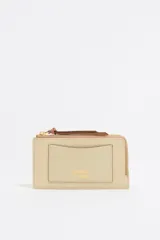 Monedero Bimba y Lola de piel color beige con estructura rígida, cierre con cremallera, tirador de cordón, logo metálico, tarjetero interior y acabados metálicos dorados.