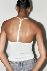 Top negro de cuello halter con escote pico y tiras finas en la espalda.