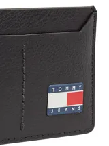 Tarjetero compacto de cuero con acabado granulado en color negro. Presenta múltiples ranuras exteriores para tarjetas y el parche distintivo de Tommy Jeans en el frente.