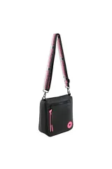 Bandolera negra con correa ancha estampada en blanco y rosa. Tiene un bolsillo externo con cierre y aplique circular rosa con un corazón blanco.