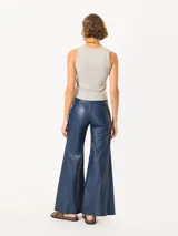 Pantalón largo de cuero ovino distress color azul marino, de pata ancha con recortes diagonales y curvos en delantero y espalda, bolsillos delanteros y bolsillos plaqué en la parte trasera.