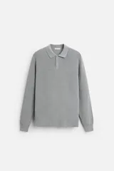 Polo gris de corte relaxed fit, tejido en hilatura de algodón. Tiene cuello solapa con cierre frontal de botonadura, manga larga y terminaciones en rib.