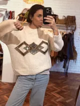 Sweater negro de tejido flexible con apliques geométricos metálicos bordados a mano.