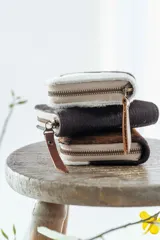 Billetera de cuero con estampado animal print de vaca en blanco y negro, con cierre de cremallera.