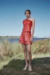 Top de un hombro color ladrillo con detalle de volados en el escote.