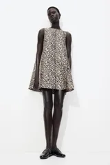 Vestido corto evasé sin mangas en tejido jacquard brillante con estampado de leopardo. Tiene escote redondo, abertura de cerradura con botón oculto atrás y forro interior.