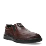Zapato casual tipo mocasín para hombre, color marrón oscuro, confeccionado en cuero liso. Presenta un diseño slip-on con elástico lateral para facilitar el calce y costuras decorativas en la puntera. Posee una suela de goma negra gruesa y antideslizante.