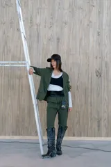 Pantalón verde con finas rayas verticales blancas, corte recto, tiro alto y bolsillos laterales.