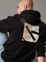 Buzo negro con capucha y cordón ajustable, de corte regular, con puños y bajo de canalé, bolsillo canguro y logo bordado tonal en el pecho y estampado en la parte trasera.