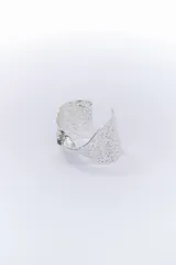 Pulsera rígida plateada con textura irregular.