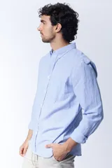 Camisa celeste a rayas verticales blancas, de corte clásico, con cuello abotonado y bolsillo en el pecho.