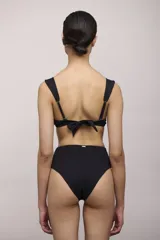 Bombacha de bikini negra de tiro alto, con textura acanalada y cobertura completa en la parte trasera.
