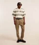 Pantalón de vestir marrón oscuro, de corte loose, con pliegues, bolsillos y cierre tradicional.