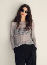 Jersey de punto calado color gris claro, con cuello redondo y manga larga acampanada.