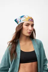 Pañuelo cuadrado de tela estampada con diseño de flores y figuras geométricas en tonos celeste, amarillo, verde y rosa.