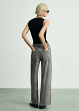 Pantalón de jean gris de corte wideleg, tiro medio, cinco bolsillos y cierre con botones.
