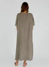 Vestido largo color gris topo, de lino, con corte amplio, mangas cortas y detalle de costuras horizontales con terminación desflecada.