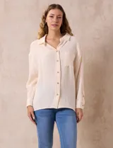 Camisa de algodón color crema, marca Robert Louis, con cuello con solapa, abertura central con botones, bolsillo aplicado en el pecho y mangas largas regulables con presilla y botón.