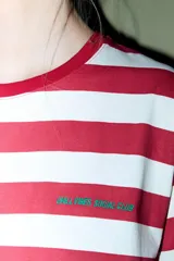 Remera de algodón con rayas horizontales rojas y blancas, cuello redondo y manga corta.