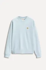 Sudadera celeste de algodón con cuello redondo y manga larga. Tiene un parche conmemorativo del 50 aniversario en el pecho y terminaciones en rib a tono.