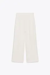 Pantalón culotte color blanco hueso, de tiro alto y pierna ancha. Cierre lateral con cremallera oculta.