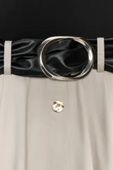 Vestido midi con falda beige con botones y cuerpo negro de cuello alto y sin mangas. Incluye cinturón negro con hebilla plateada.