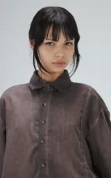 Camisa manga corta color gris con efecto desgastado, corte holgado y cierre frontal con botones.