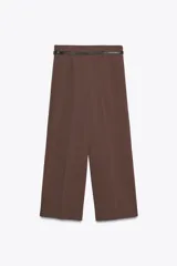 Pantalón culotte color verde oliva, de tiro medio y pierna ancha. Incluye cinturón ajustable con hebilla metálica y cierre lateral con cremallera oculta.