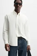 Camisa azul marino de algodón con textura jacquard, corte relaxed fit, cuello solapa, manga larga con puños abotonados y cierre frontal con botones.