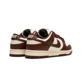 Zapatillas Nike Dunk Low, color blanco y marrón chocolate, con cordones marrones y suela color crema.