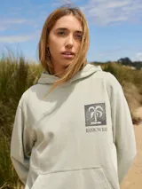 Buzo con capucha color verde claro, con estampado de motivos playeros en la espalda y texto "Rainbow Bay The Goldcoast GEM".