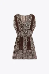Vestido corto con estampado de cachemira en tonos marrones, beige y verde. Tiene escote en pico con abalorios, mangas cortas y cintura elástica con cinturón fino.
