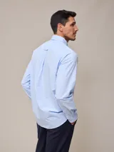 Camisa de manga larga con estampado a cuadros azul y blanco, confeccionada en algodón con efecto peach y bolsillo en el pecho.