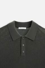 Polo de punto color verde oscuro, tejido en hilatura de algodón, de corte regular fit, con cuello solapa y cierre frontal de botonadura.