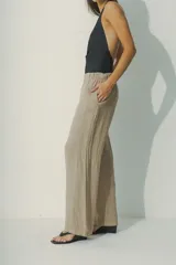 Pantalón de lino color beige, de corte palazzo con cintura elastizada.