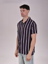 Camisa de manga corta con rayas verticales blancas y azules, cuello americano y bolsillo en el pecho.
