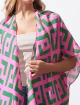 Kimono tejido con estampado geométrico en tonos rosa y verde, con terminación de ruedo con borlas verdes.