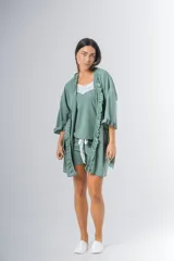 Bata kimono verde agua confeccionada en algodón con textura acanalada y volados en los bordes. Tiene mangas al codo, largo arriba de la rodilla y lazo de algodón para ajustar en la cintura.