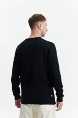 Buzo de punto color beige, con cuello redondo y mangas largas. Tejido con textura piquet y puños acanalados. Corte regular.