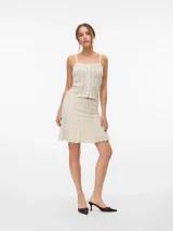 Top tejido color crema, sin mangas, con cuello cuadrado, botones frontales y diseño calado.