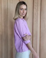 Camisa color beige claro con cuello con volados y mangas 3/4 abullonadas.