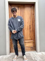 Buzo gris con cuello redondo y logo estampado en el pecho. Corte oversize.