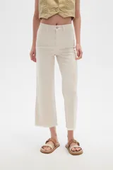 Pantalón jean blanco, recto y de calce alto con terminación desflecada.