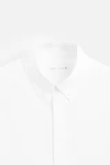 Camisa celeste de algodón, corte relaxed fit, cuello abotonado, manga larga con puños abotonados y cierre frontal con botones.