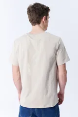 Remera básica de algodón color beige con bolsillo en el frente y corte regular.
