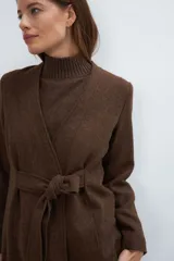 Chaqueta corta color beige, entallada, con escote en V, manga larga y cierre frontal con lazo fijo. Confeccionada en lana fina sin teñir, con bolsillos escondidos y terminaciones enviadas. Hecha 100% en Uruguay.