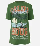 Remera verde militar de algodón con cuello redondo y mangas cortas. Estampado frontal con palmeras, olas y texto "Califa Hour".
