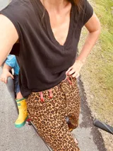 Pantalón de jean con estampado animal print en tonos beige y negro, de corte ancho y tiro medio. Presenta detalles de cuero bordó en la pretina y los bolsillos.