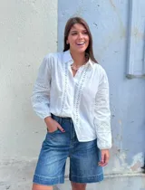 Camisa blanca de manga larga con detalles de encaje en el frente y las mangas.