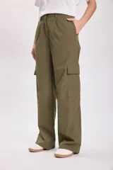 Pantalón cargo color verde oliva, de corte ancho y tiro alto, con bolsillos laterales y cierre frontal con cremallera y botón.